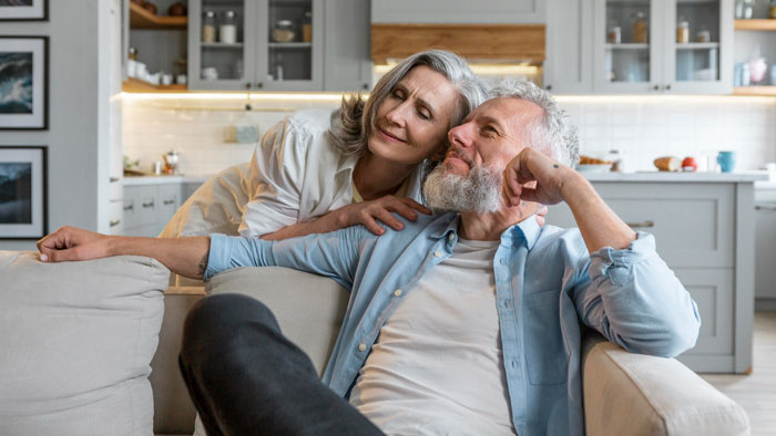 Older couple relaxing in a modern kitchen, highlighting parents who abandoned their daughter and faced her refusal to help.
