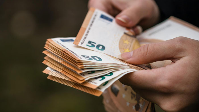 Hands counting 50 euro banknotes, representing a lady refusing to help cruel parents who abandoned her.