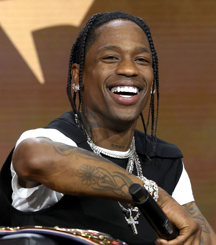 Smiling male star with braided hair and diamond jewelry, representing one of the most disliked stars of this year.