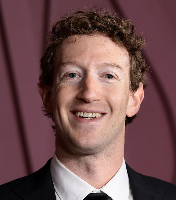 Close-up of a smiling man with curly hair in formal attire representing one of the most disliked stars of this year.