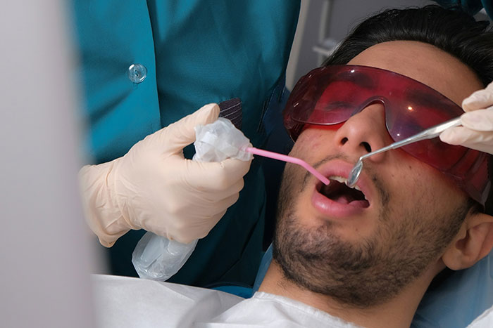 A patient wearing protective glasses receiving dental treatment, relating to doctors sharing wrong self-diagnoses.
