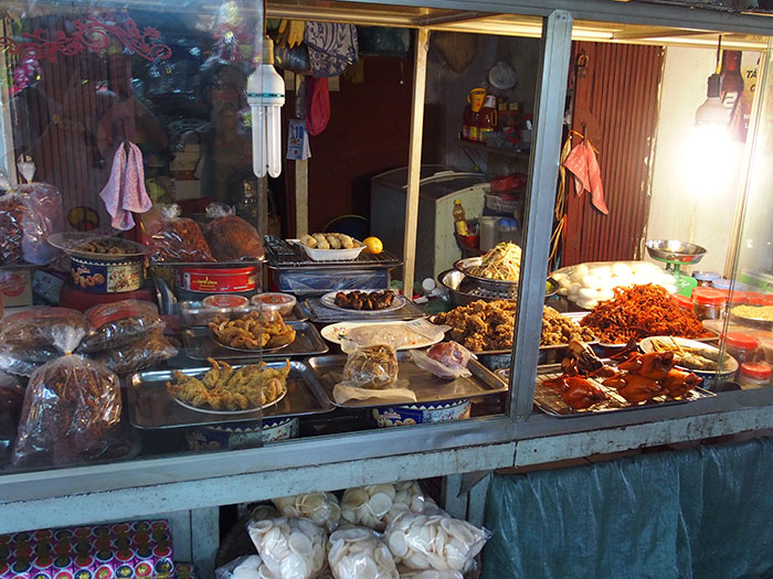 Street food vendor stall with various fried and cooked dishes, representing people from different countries denying popular myths.