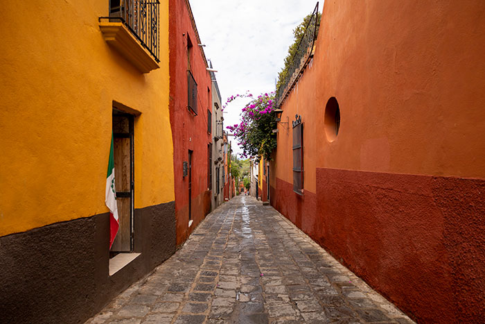 Colorful narrow street in Mexico, illustrating people from different countries who deny popular myths about foreigners.