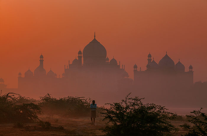 Silhouette of people from different countries near iconic architecture at sunset dispelling popular myths foreigners believe.