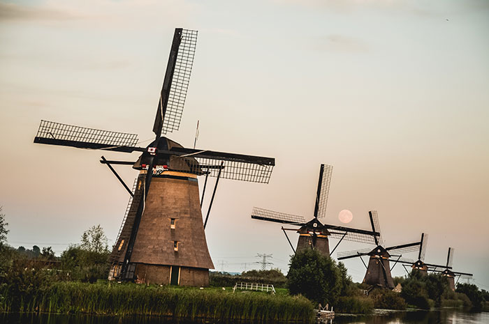 Traditional windmills at sunset, representing people from different countries denying popular myths foreigners believe.