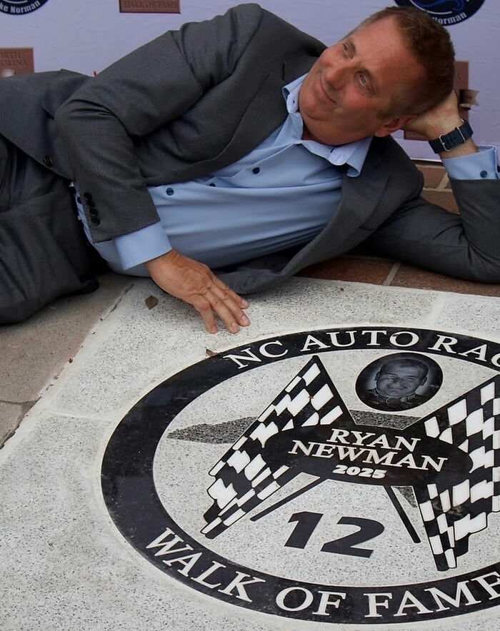Man in a gray suit lying next to a Walk of Fame star, related to Greg Biffle's wife and harrowing plane crash text.