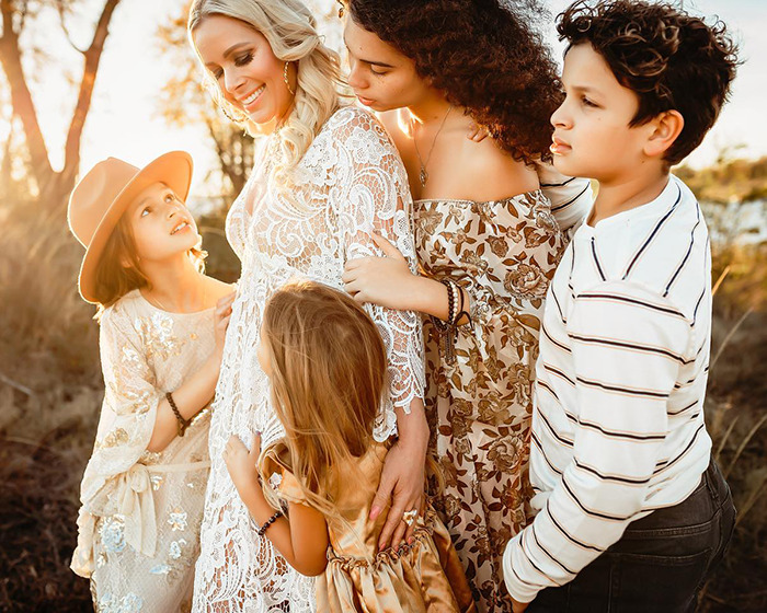 Netflix star and mom of three sharing a heartfelt moment outdoors with her children during golden hour sunlight.