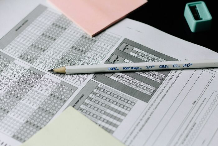 Scantron test forms with a pencil, representing signs that show someone is still stuck in their high school era years later.