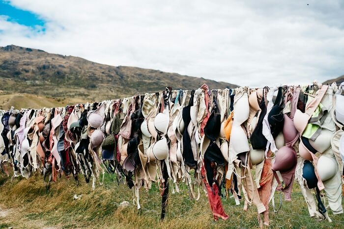 A long line of assorted bras hanging outdoors against a mountain backdrop, illustrating small design mistakes.
