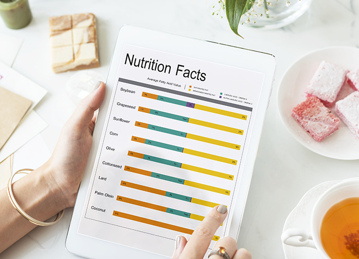 Person holding tablet displaying nutrition facts chart, unrelated to 5-month-old passing away due to pseudoscience issues.