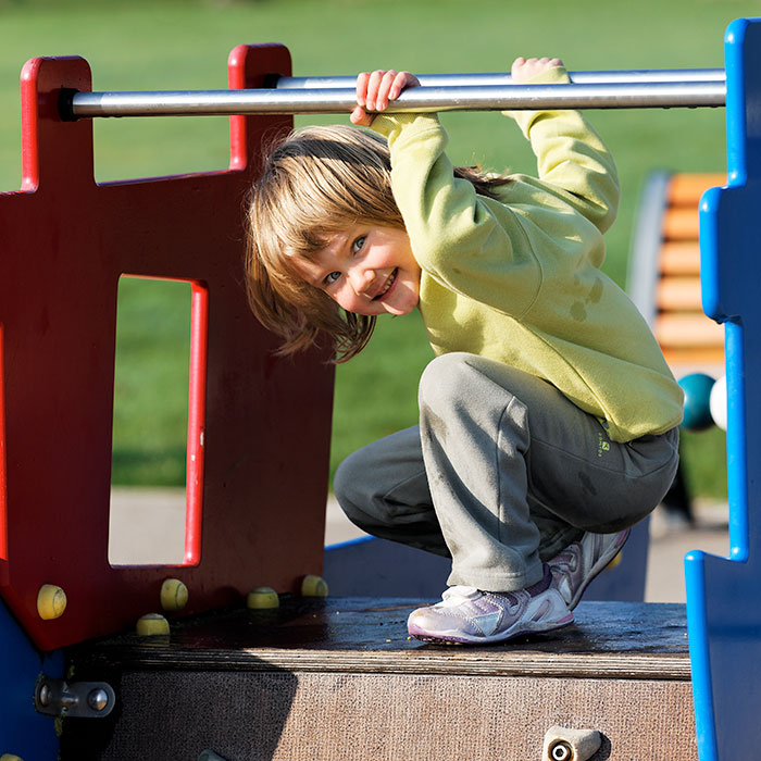 Child playing on playground equipment outdoors, highlighting moments parents realize kids show selfish behavior traits.