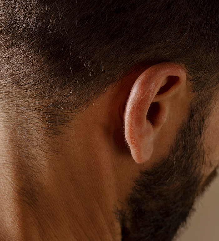 Close-up of a man's ear and side of head, illustrating moments parents realized their kids show selfish sociopath traits.