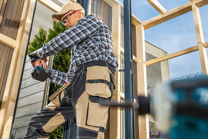Man using a power drill to build a wooden frame, illustrating a legal shortcut to make life easier.