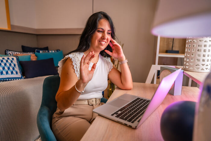 Woman smiling and waving during a video call, illustrating moments when people found out something terrifying about their partner.