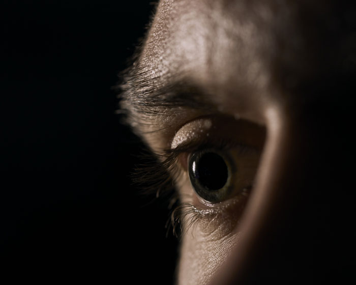 Close-up of a wide eye in darkness, capturing fear and anxiety from a scariest moments experience.