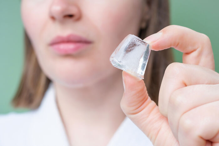 Close-up of a person holding an ice cube, illustrating wild patient confessions doctors have truly heard.
