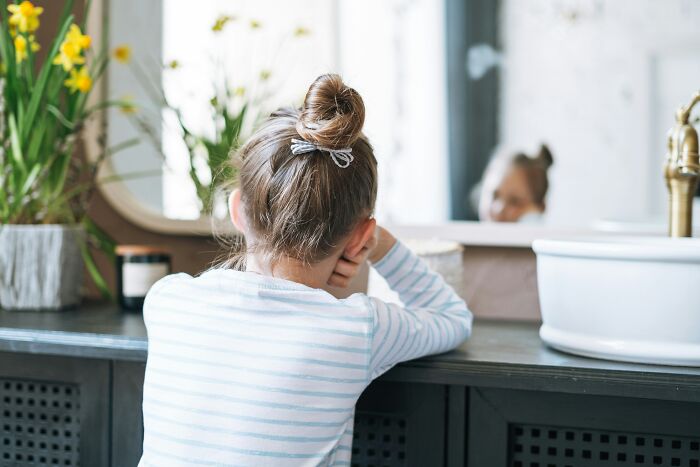 Young girl looking in the mirror, reflecting on wild patient confessions doctors have truly heard in medical settings.