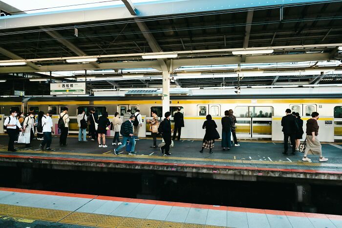 People waiting at a busy train station platform, capturing a moment people still talk about as something scary they saw.