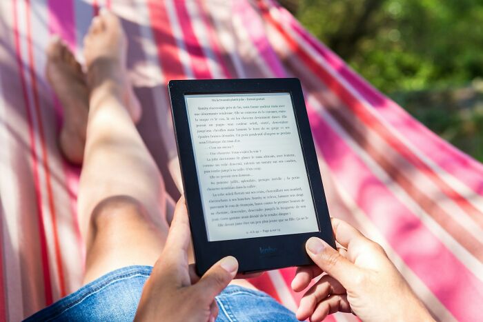 Person relaxing in a hammock holding an e-reader, illustrating small design mistakes affecting user experience outdoors.