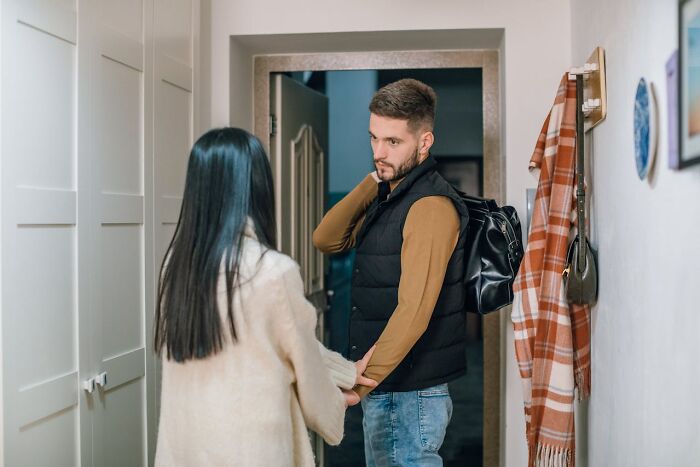 A couple exchanging sassy and clever words in a tense moment inside a modern home hallway.