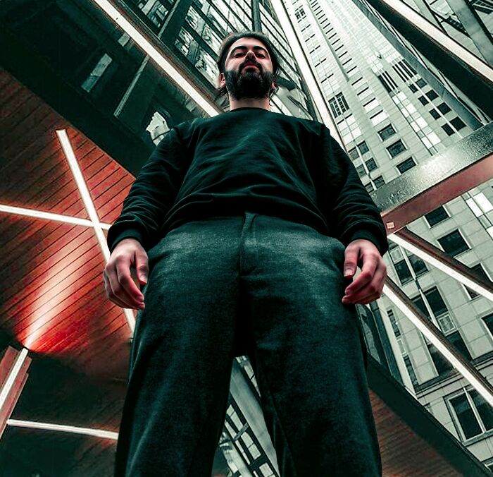 Man standing confidently in an urban setting surrounded by tall buildings illustrating facts that sound made up but true