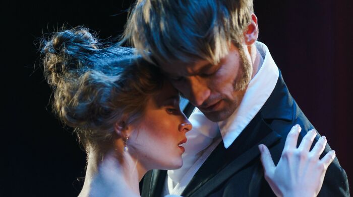 Two actors in period attire performing an intense scene, relating to who played the role of Oppenheimer.