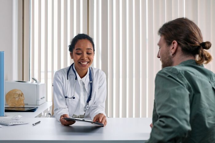 Smiling female doctor with stethoscope talking to patient, showing funny, clever and sassy things said in the moment.