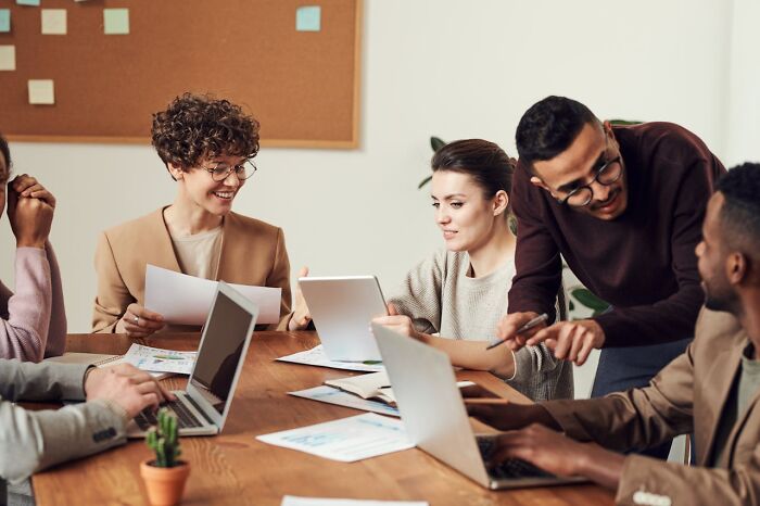 A diverse group of people sharing funny, clever, and sassy remarks during a lively team meeting.