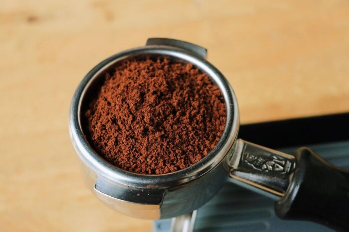 Portafilter filled with ground coffee, highlighting disturbing truths about sleepless nights and horrifying information.