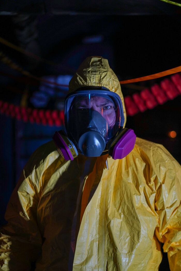 Person in yellow protective suit and gas mask, illustrating crazy airport stories with unusual safety gear.