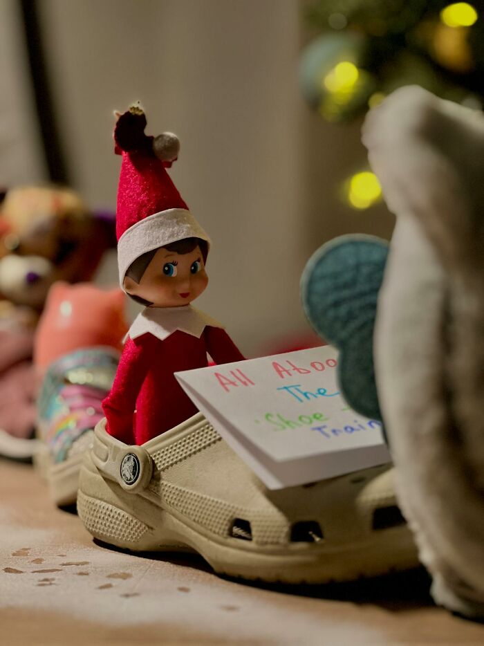 Elf on the Shelf doll sitting inside a shoe with a handwritten note, a popular modern parenting trend during holidays.