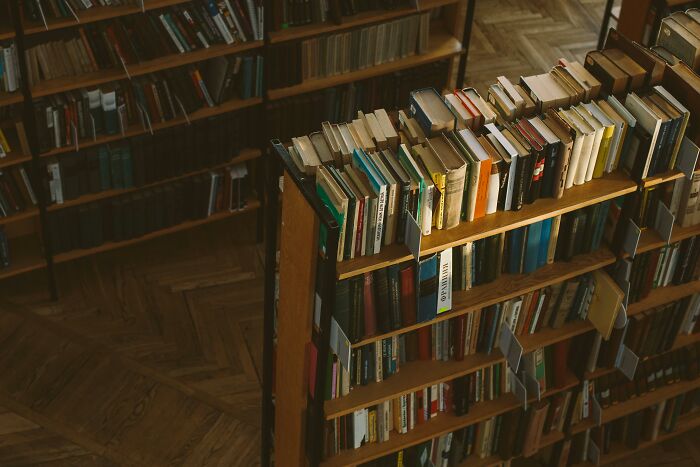 Bookshelf filled with various books in a dimly lit library, illustrating the concept of horrible gifts people dislike.