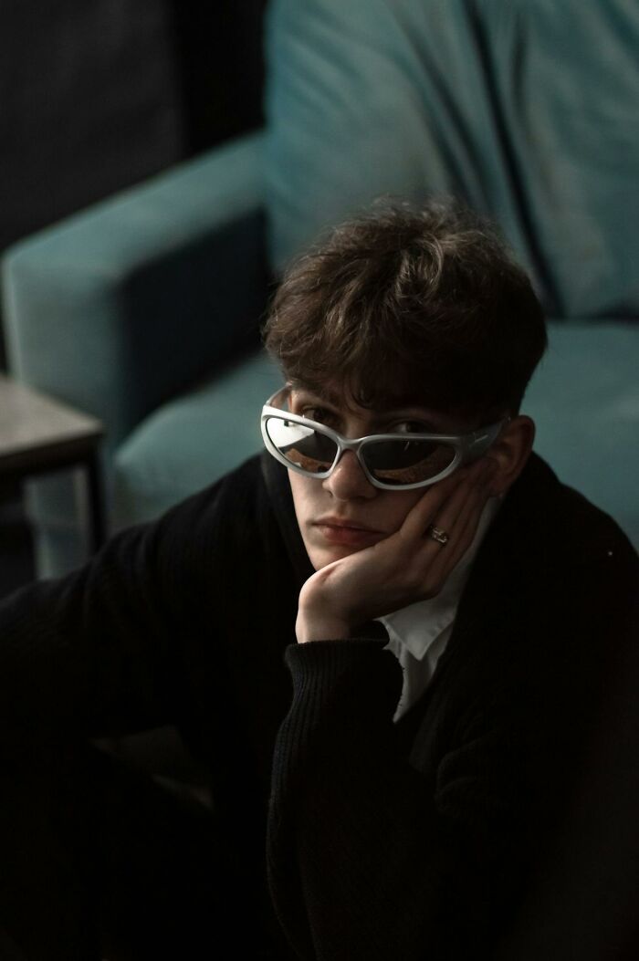 Young person wearing unusual sunglasses indoors, representing unusual personal belongings found at lost and found.