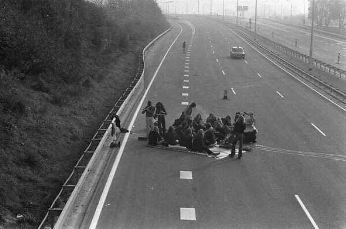 Group of people gathered on a highway during a protest, captured in a classic and iconic historical black and white photo.