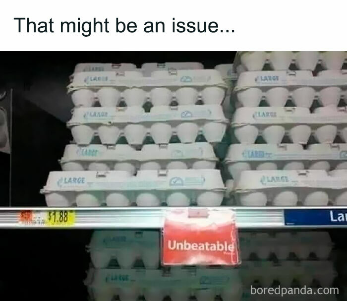 Egg cartons stacked unevenly on a grocery shelf with a sign labeled unbeatable, illustrating a hilarious food meme moment.