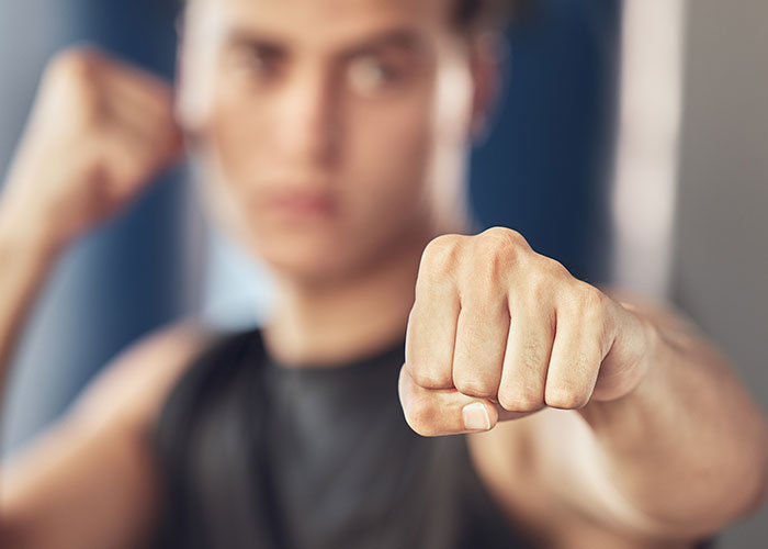 Young man in a black tank top showing a fist, illustrating surprising facts and misconceptions about prison life.