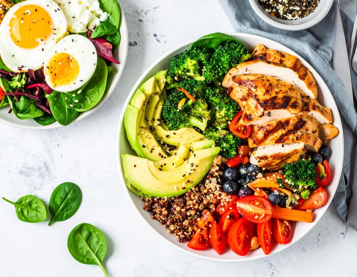 Healthy meal bowl with grilled chicken, avocado, quinoa, broccoli, and fresh vegetables promoting long-term mental and physical health.