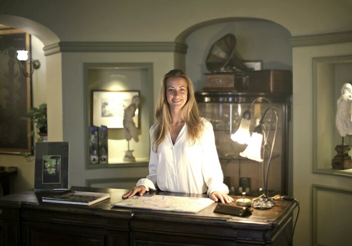 Woman standing behind a vintage desk in a warmly lit room, representing stories of quitting jobs in record time.