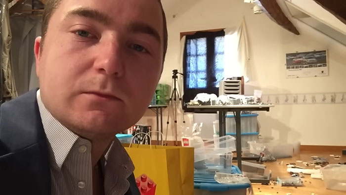 Man staying calm in a messy room with scattered objects, illustrating rage-inducing moments and patience needed.