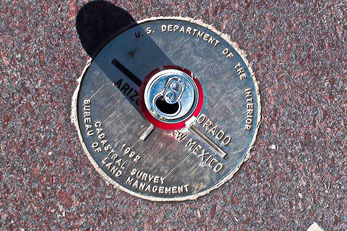 Survey marker on ground with soda can top casting randomized shadow representing random facts concept