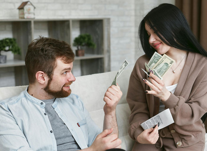 Woman and man exchanging money with receipt, illustrating conflict over family heirloom ring pawned and bought back.
