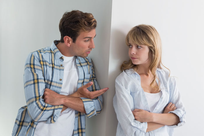 A man and woman in casual clothes having a tense conversation about refusing to establish relationship with fathers and kids.
