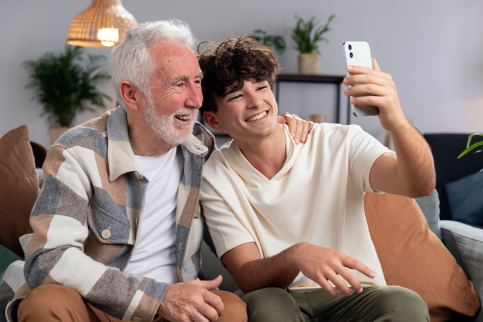 Grandfather and teenage grandson taking a selfie together, highlighting connection despite refusing establish relationship fathers kids.