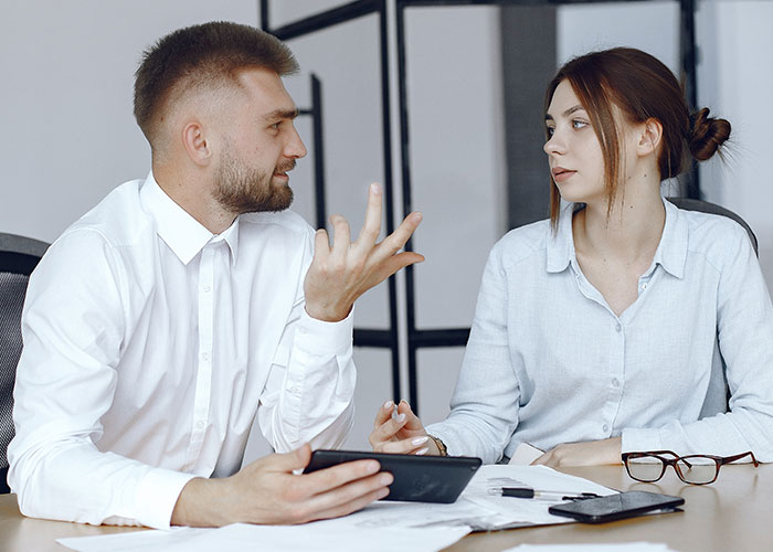 Man and woman in office having tense discussion about shady fund manager refusing to show receipts during meeting