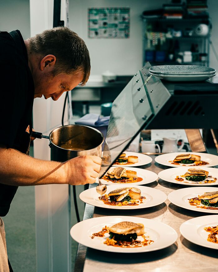 Chef carefully plating gourmet dishes in a professional kitchen, reflecting moments that made chefs stop cooking professionally.