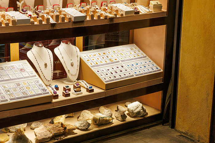Jewelry store display with various rings, necklaces, and gemstones showcasing clever criminal tactics to outsmart police.