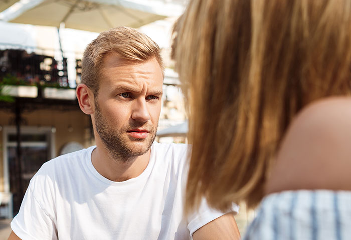 Young man attentively listening during a social conversation, illustrating psychological cheat codes for easier social life.