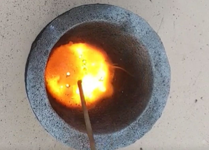 Close-up of a burning matchstick inside a stone bowl with bright orange flames, illustrating diabolical revenge stories.