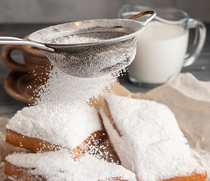 Powdered sugar being sifted onto pastries, capturing the panic on his face in a moment of scoffing at seriousness.