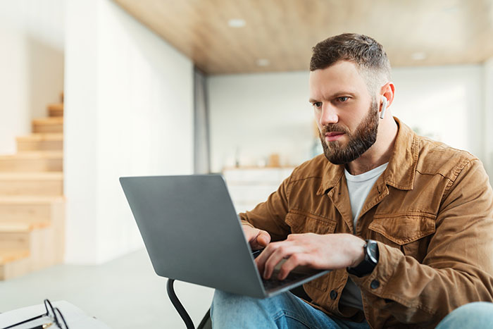 Man with a panic on his face intensely focused on a laptop, illustrating moments people scoffed at serious situations.